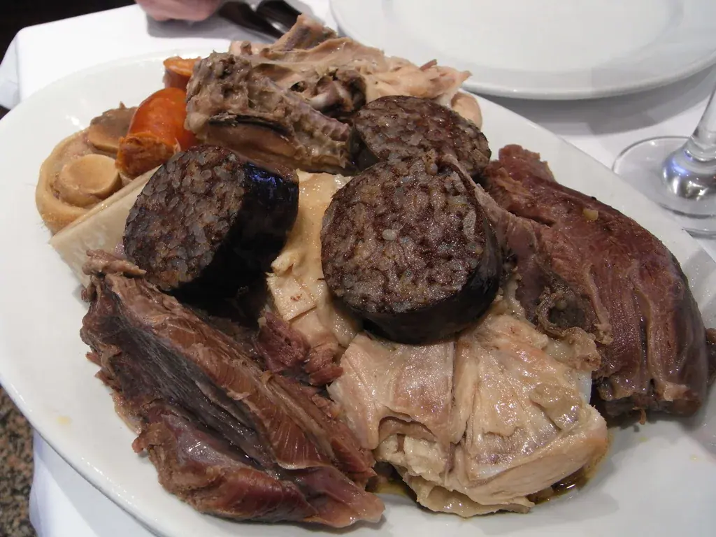 Fuente del tercer vuelco de un cocido madrileño con morcilla en rodajas, chorizo, tocino y carnes de ternera y de pollo
